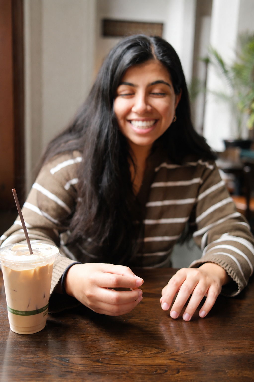 Sana Aslam smiling at a café